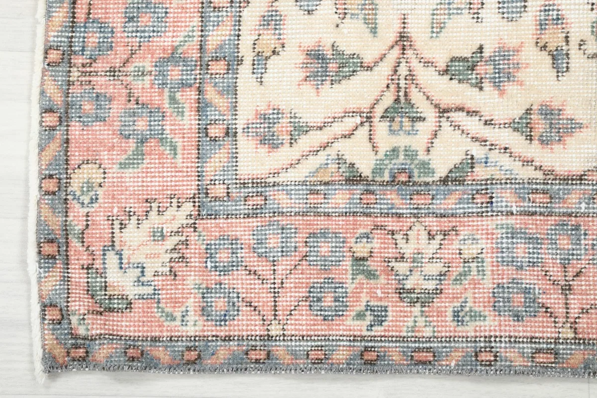 Close-up of the rose-colored border with its geometric and floral motifs.