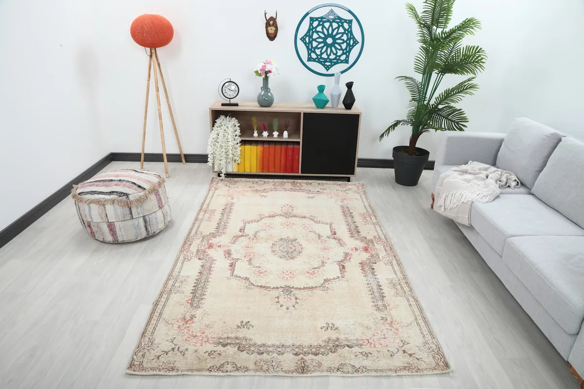 Ivory vintage rug with rose and gray motifs placed in a modern living room setting