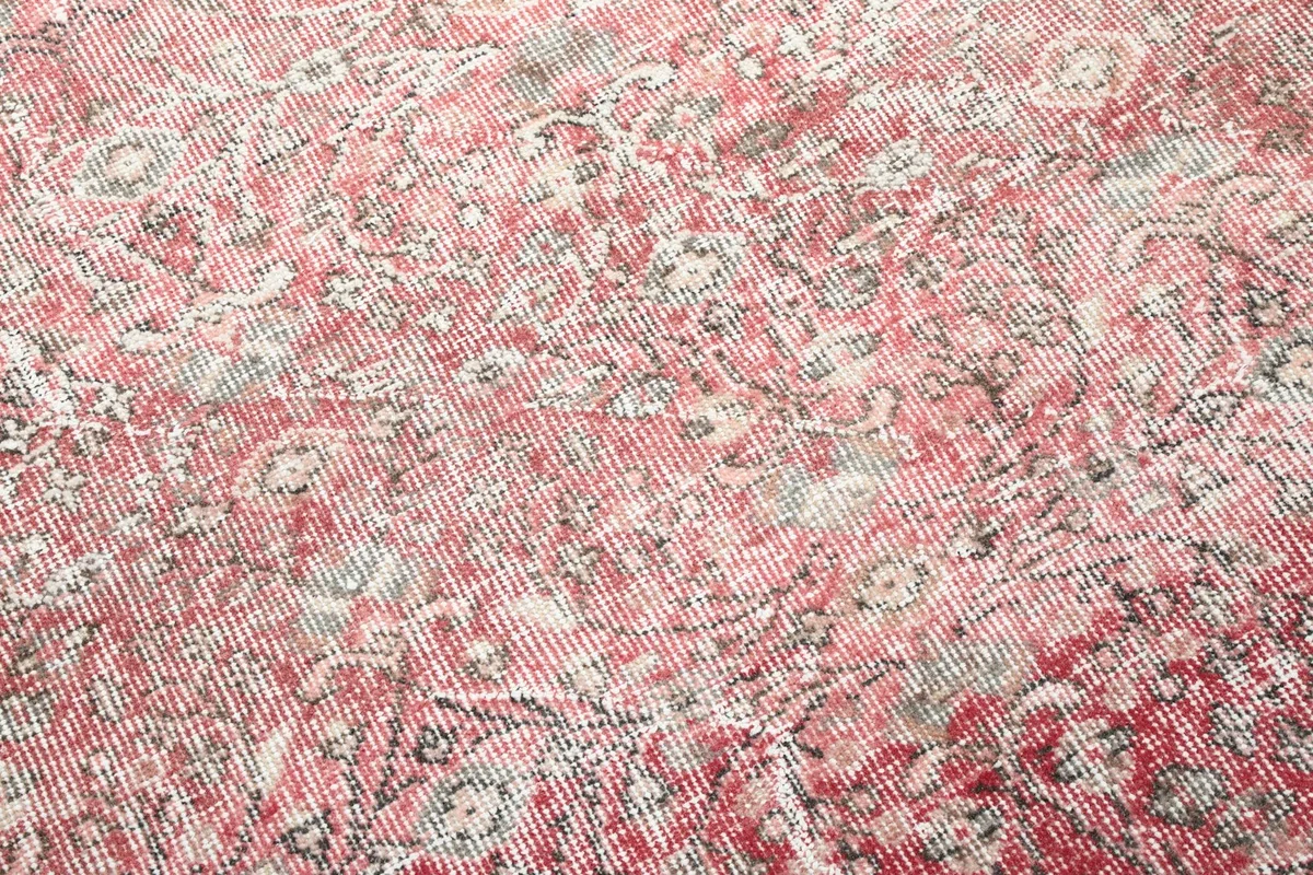 Close-up of the low wool pile, showing the texture and faded rose colors