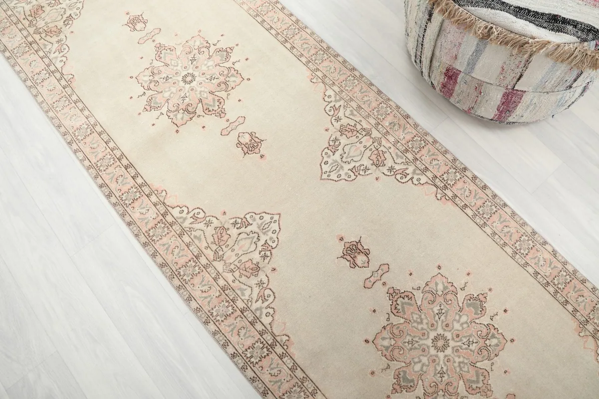 Angled view of the runner rug, capturing the repeating medallion and floral motifs