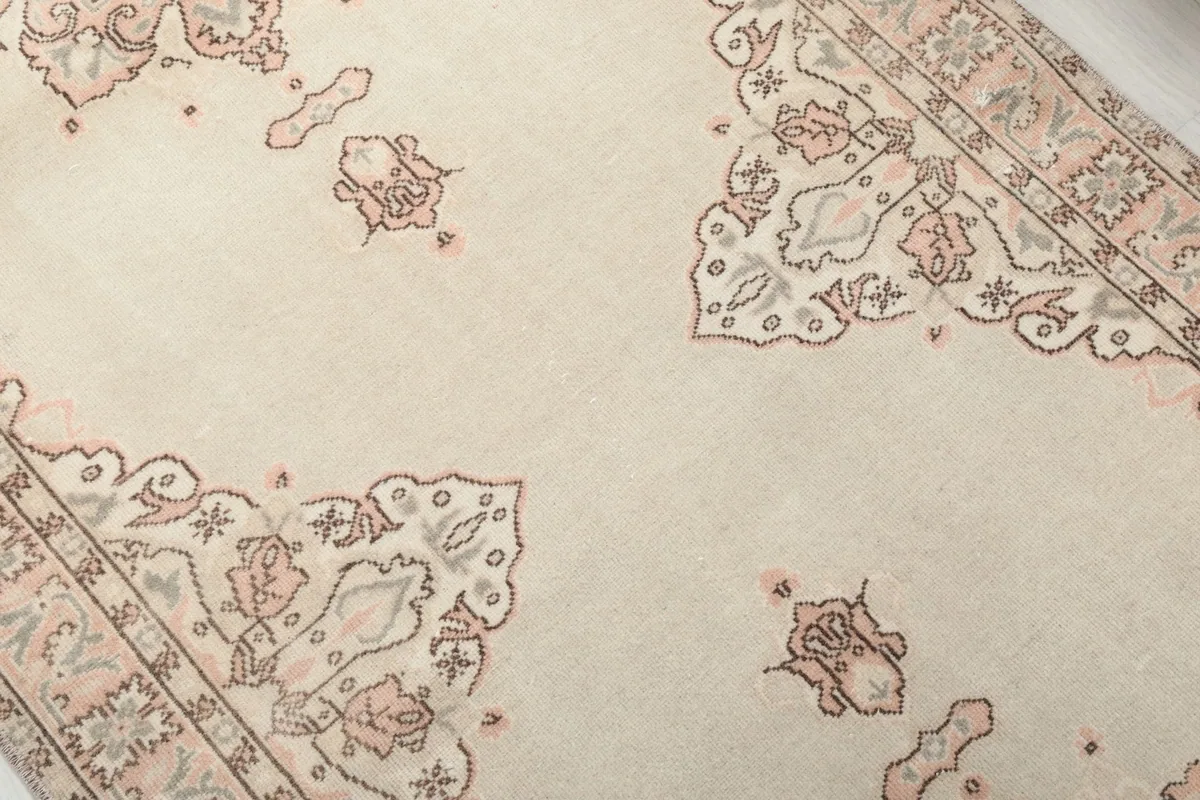 Close-up detail of the beige field and rose and gray floral patterns on the rug