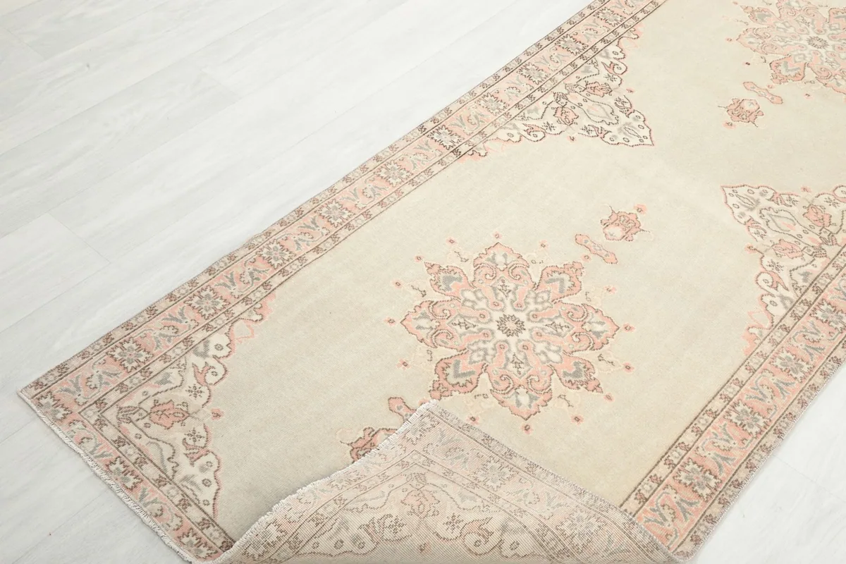 Angled view of the runner rug with a corner gently folded to show the back