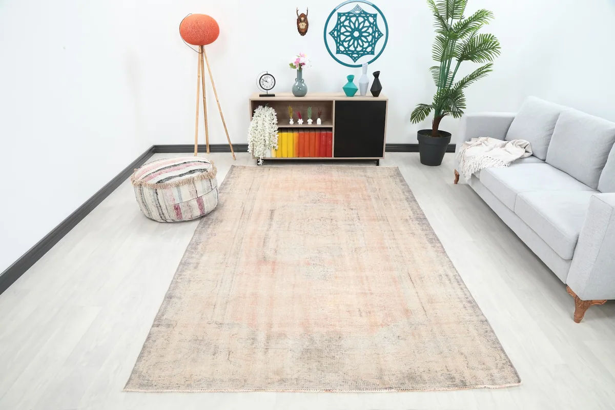 Vintage pink and gray area rug displayed in a modern living room setting with a light sofa