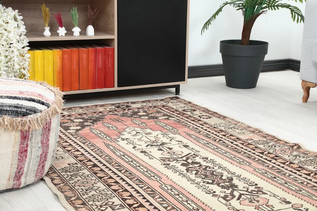 Close-up of the rug in a room, showing the central design and colors near furniture