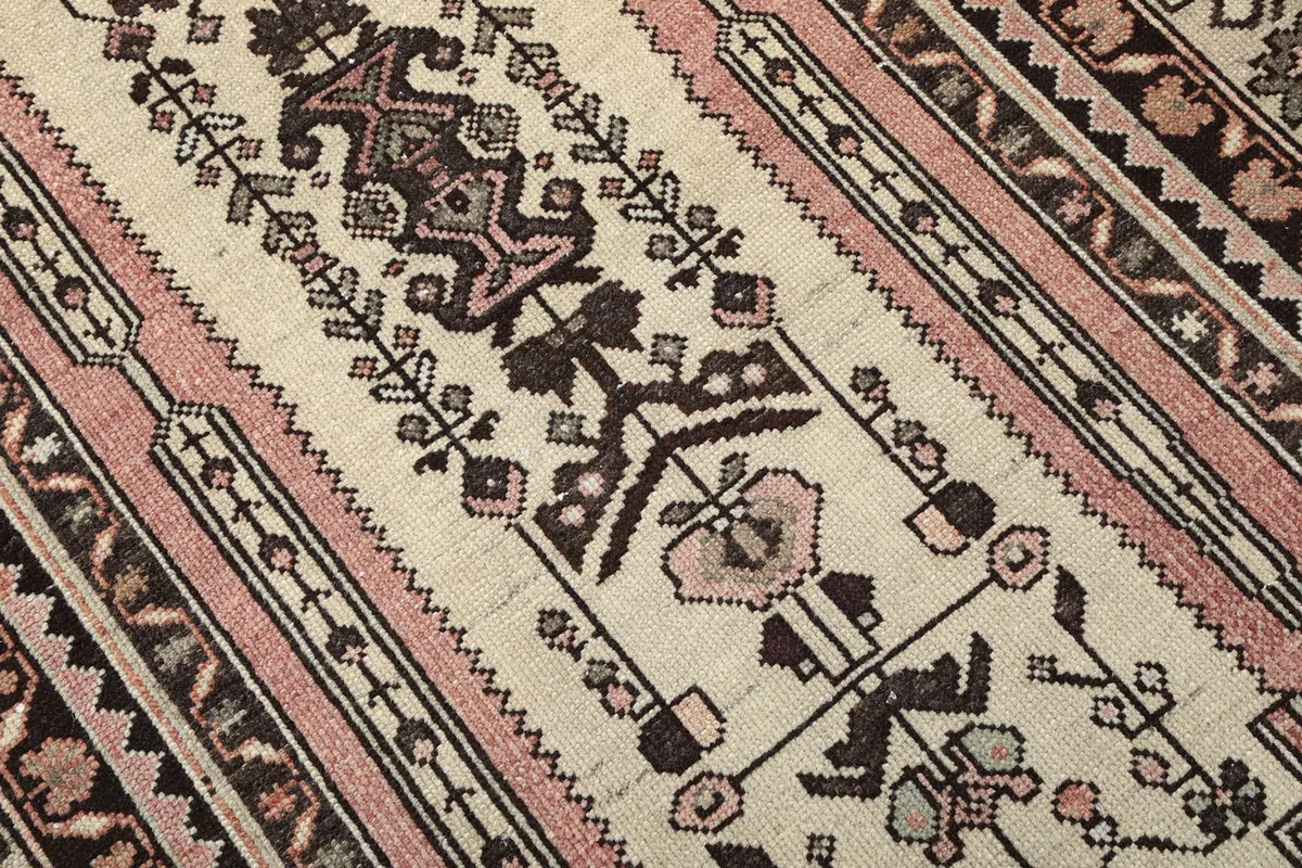 Close-up detail of the hand-knotted wool pile and geometric patterns in the rug