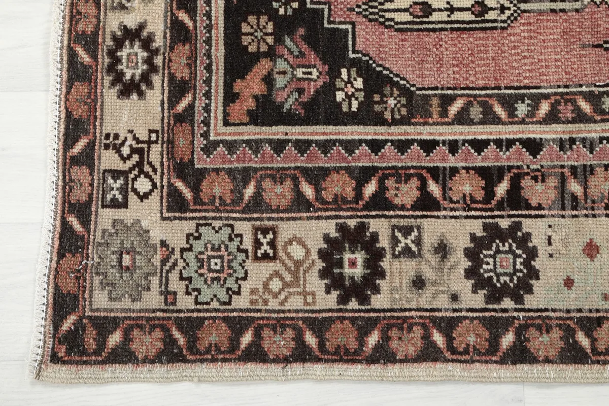 Corner detail of the rug showing the distinctive border patterns and colors