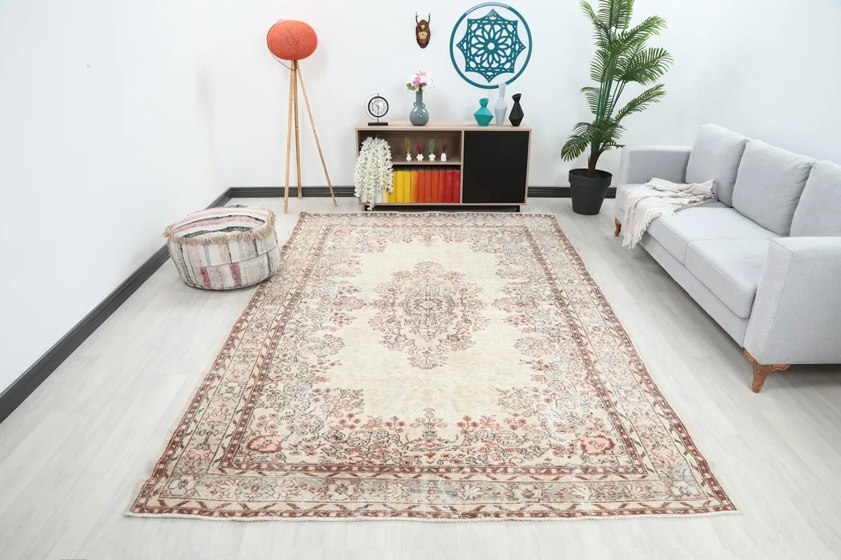 Large ivory and rose vintage rug shown in a modern living room setting