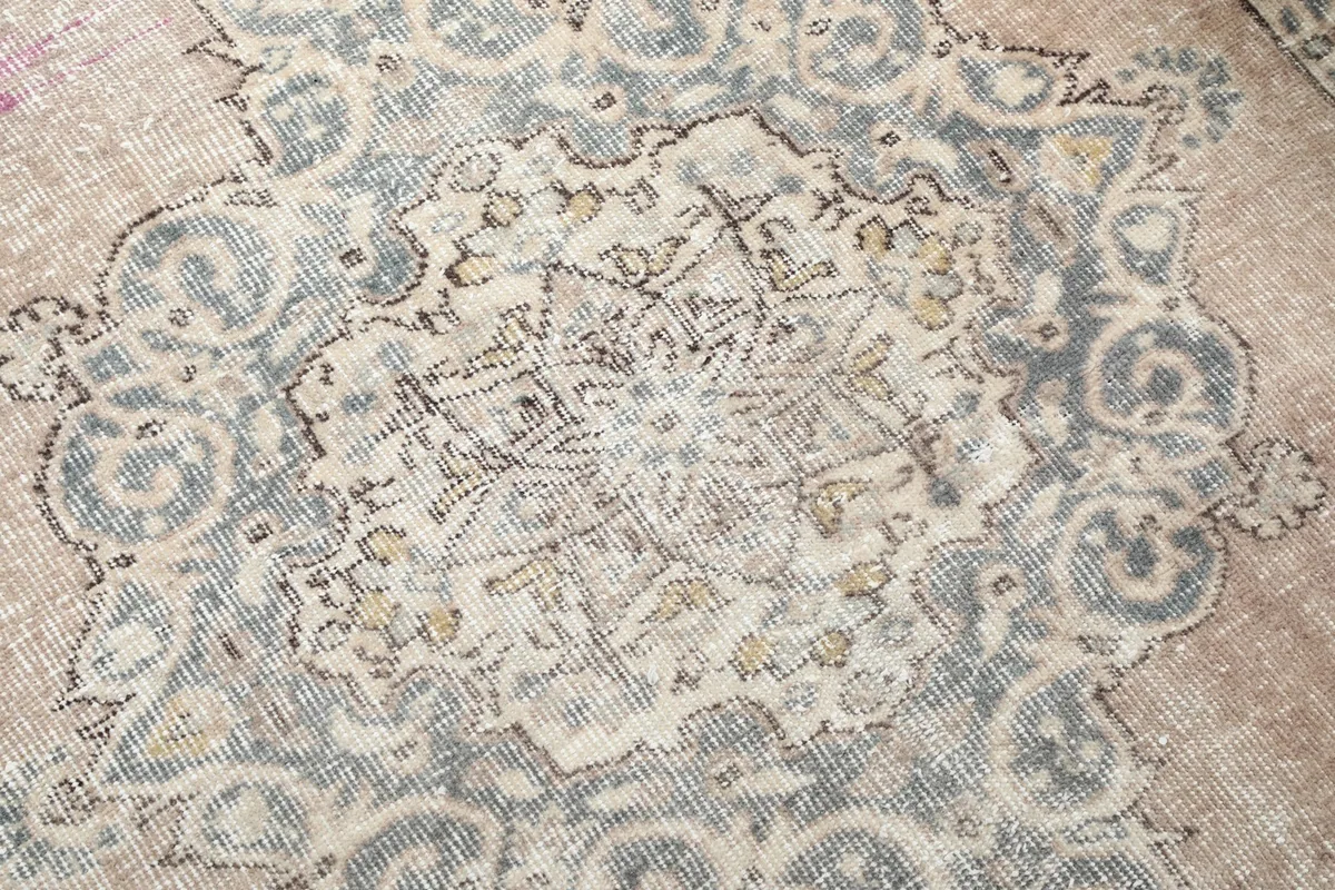 Close-up of the intricate central medallion design with gray and ivory tones