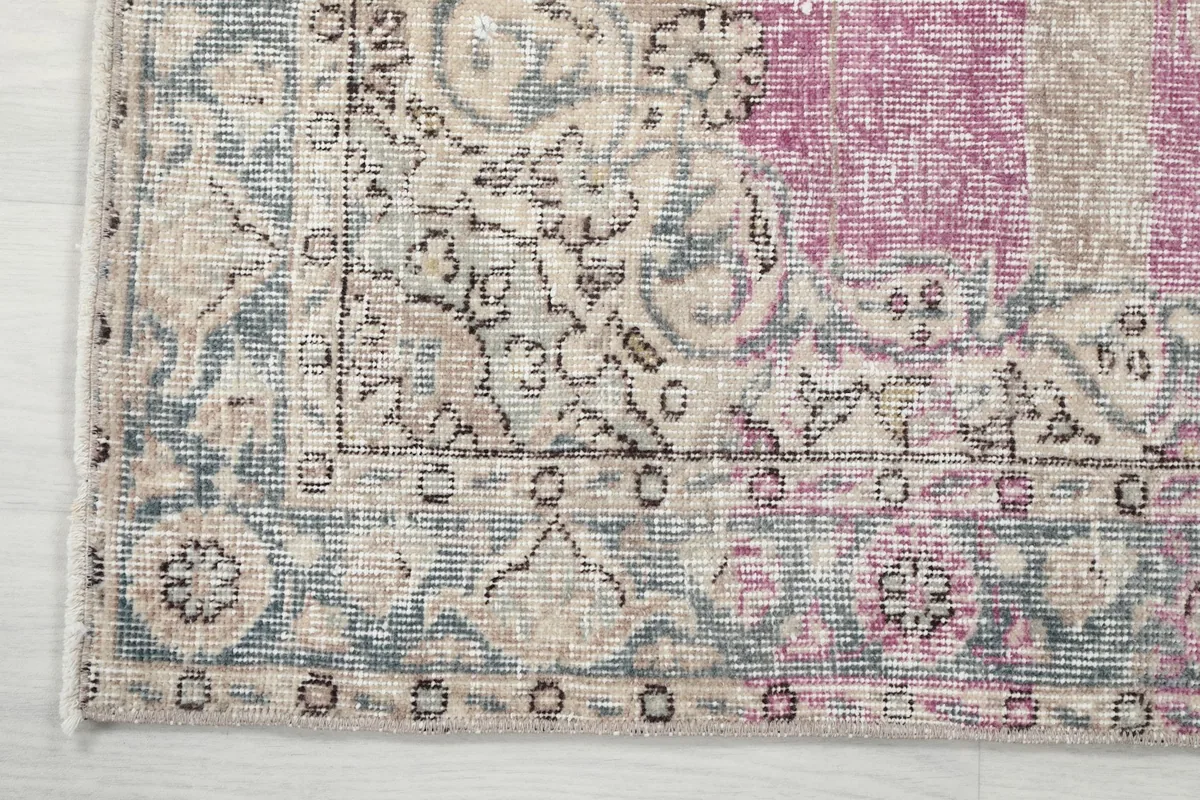Detail of the rug's border pattern, showing geometric motifs and color variations