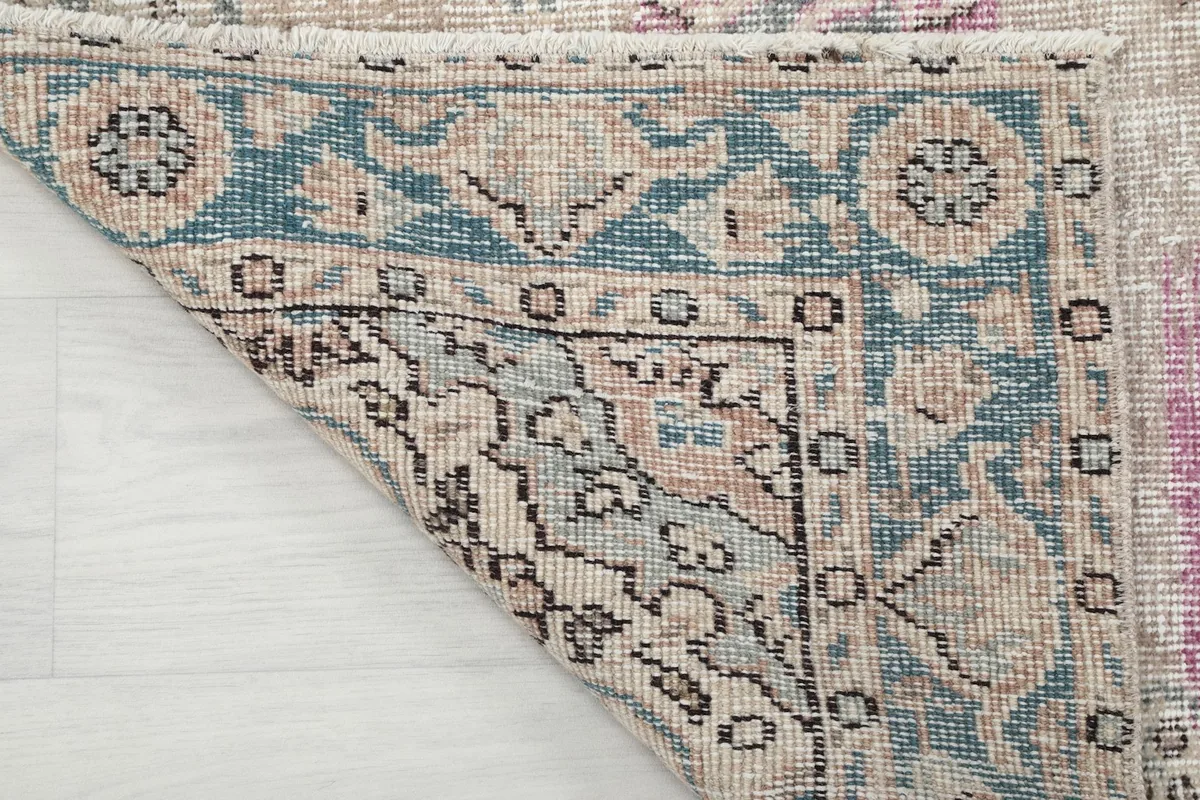 Close-up of the back of the rug, showcasing the hand-knotted wool on cotton foundation