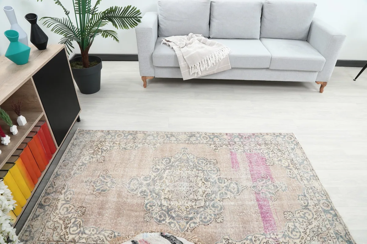 Overhead view of the rug in a room, showing its placement in front of a sofa and cabinet
