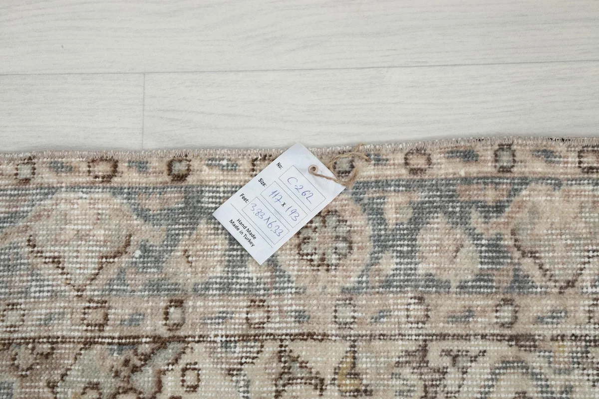 Detail of the rug's edge with a product tag showing dimensions and item number