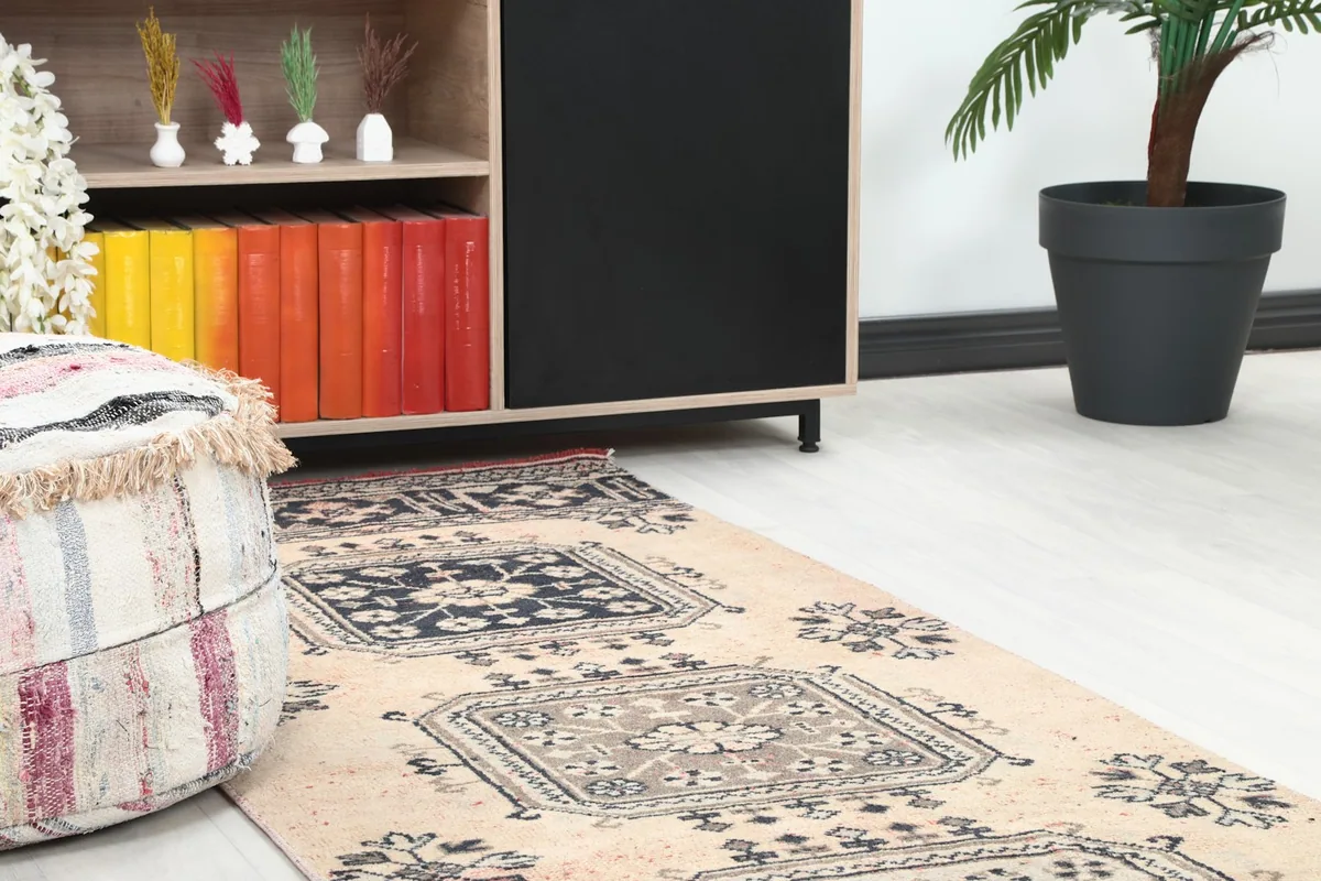 Close-up of the runner rug in a room setting, showing the pattern next to a textured ottoman.