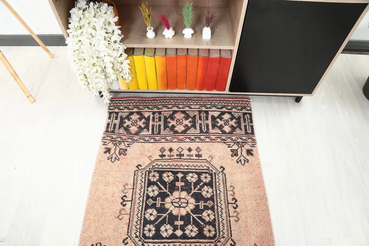 Top-down view of one end of the runner rug in a room, next to a console table.