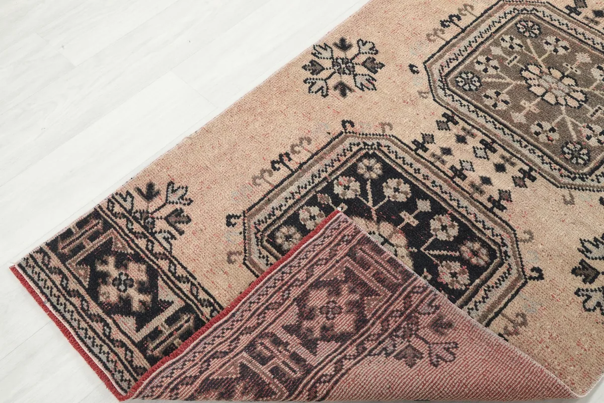 View of the rug's reverse side near a folded corner, showing the hand-knotted construction.