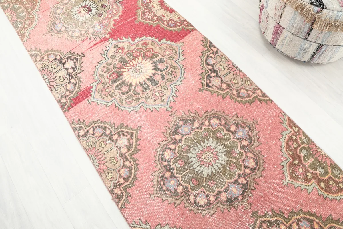 Diagonal view of the runner rug, emphasizing the repeating medallion design and color blend
