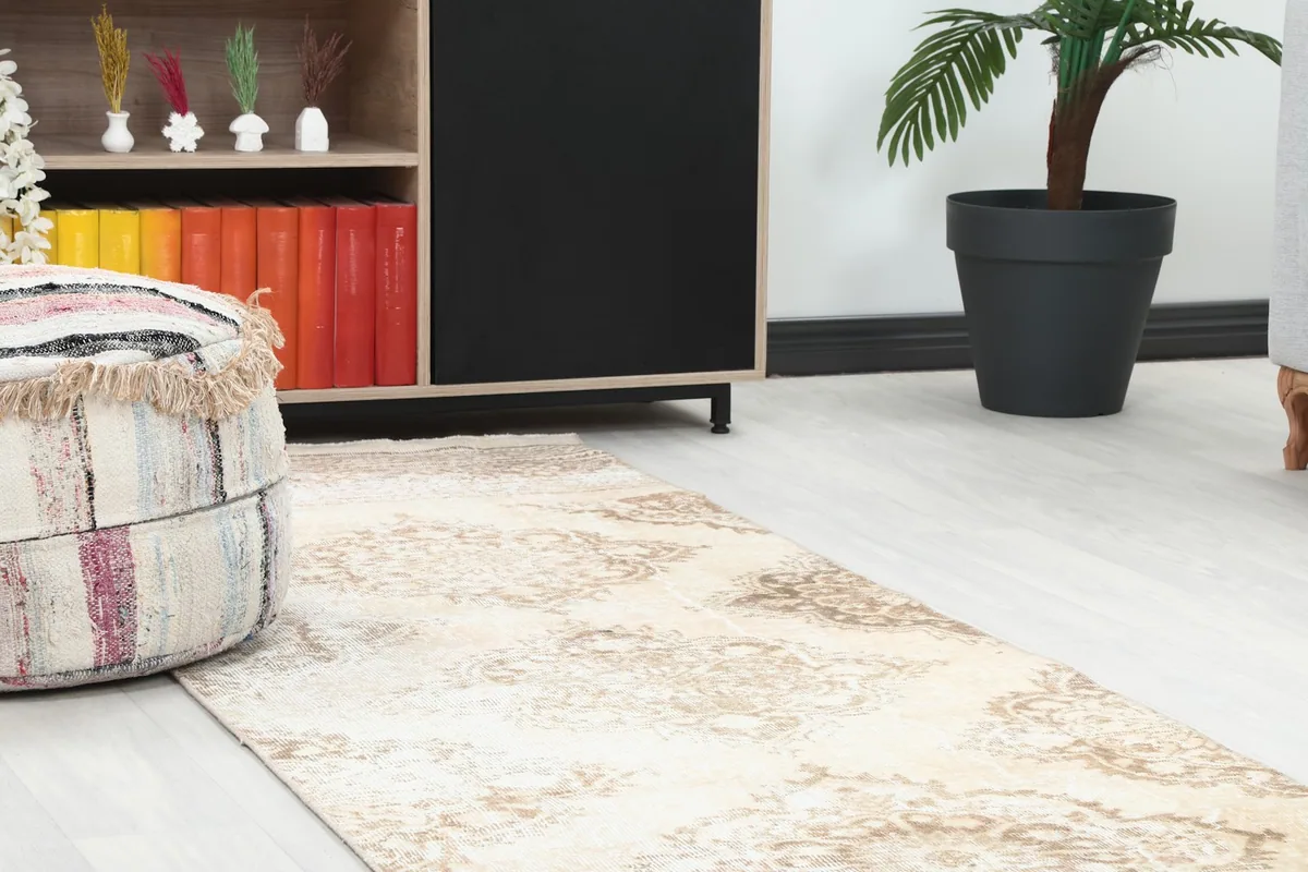 Close-up view of the runner's end near a pouf and cabinet, showing the subtle color variations.
