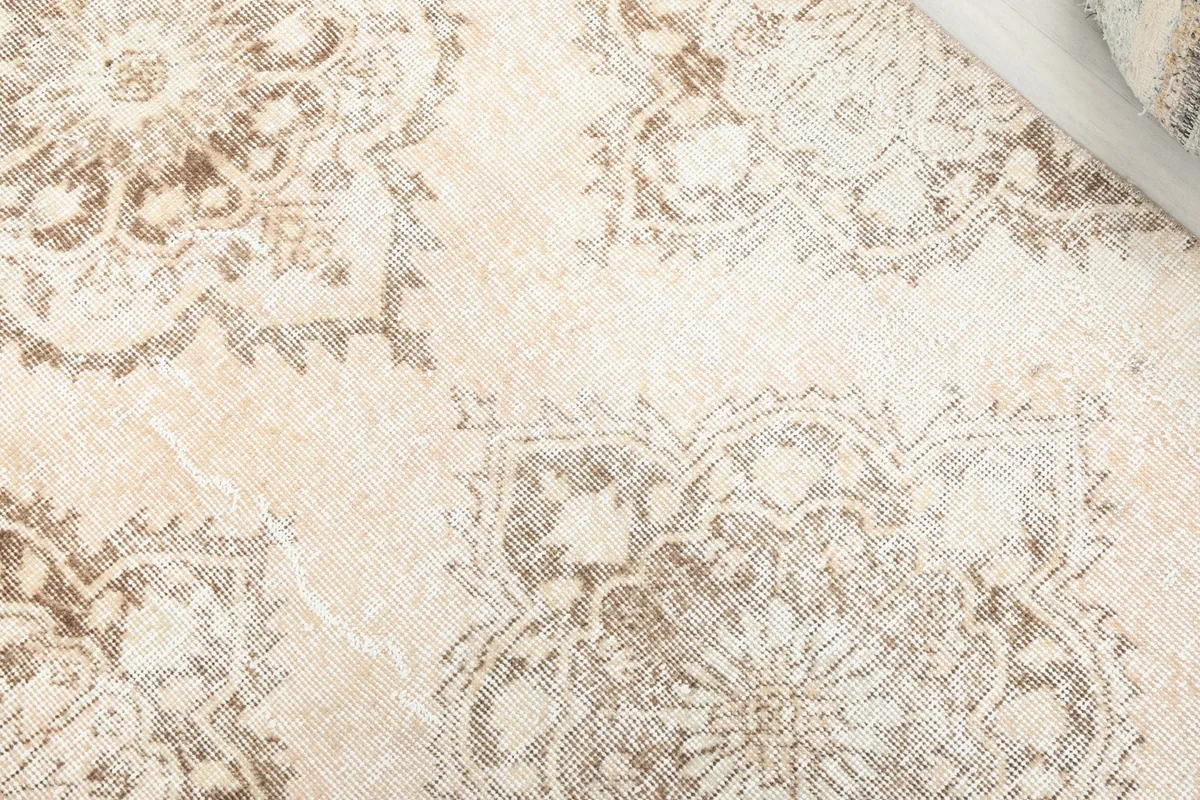 Close-up of the hand-knotted wool pile, showing the intricate medallion pattern and gentle wear.