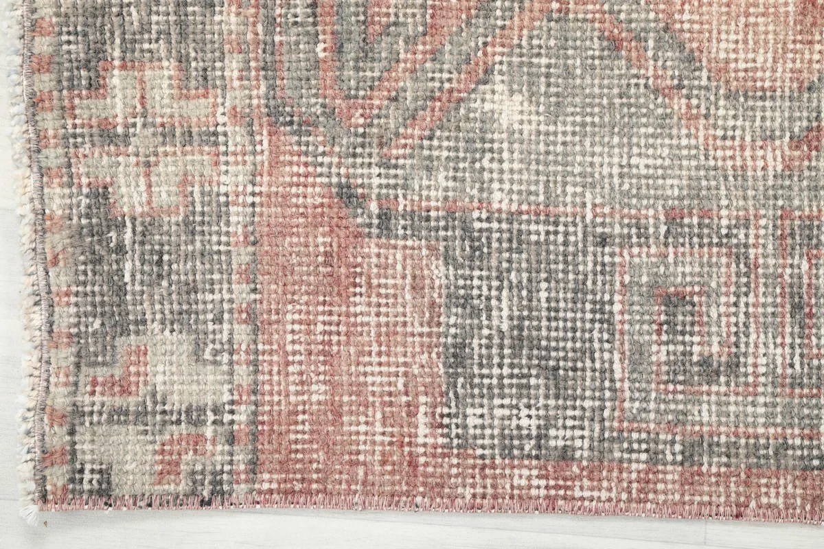 Detailed view of the rug's edge, showing the subtle border pattern and the finished side.