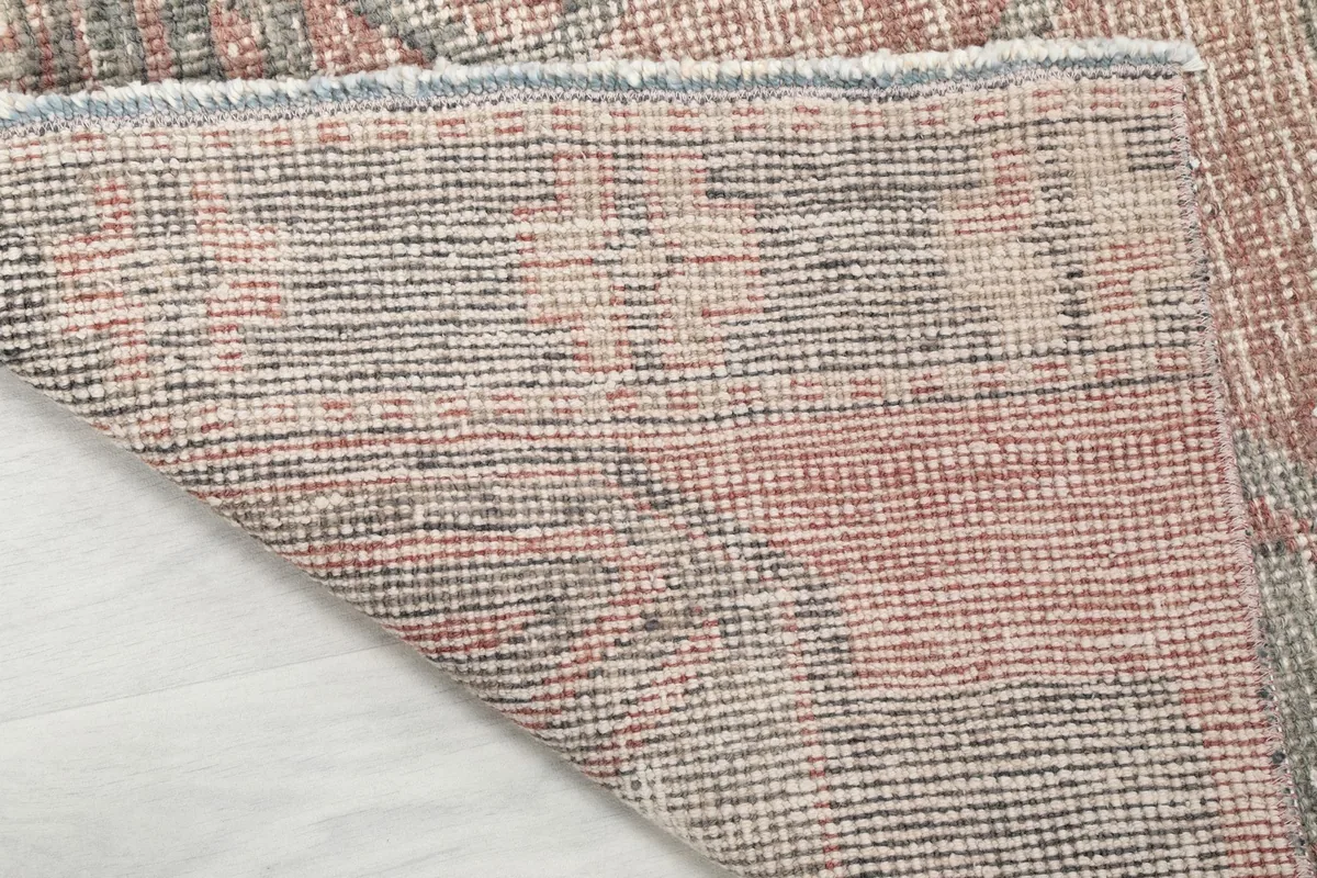 View of the rug's cotton foundation and the back of the hand-knotted wool pile.