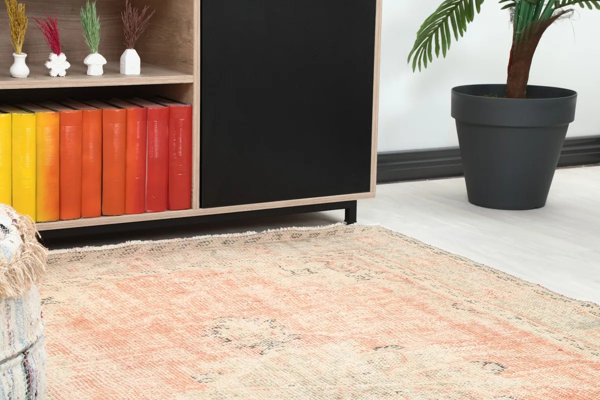 Close-up of the rug's corner and border, showing the muted gray and beige tones.