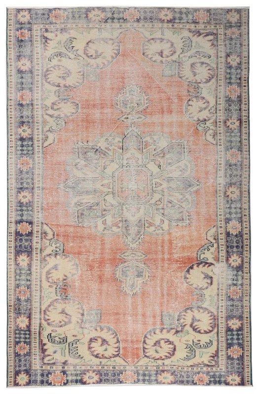 Full overhead view of a vintage rust and navy medallion Anatolian rug on a white background