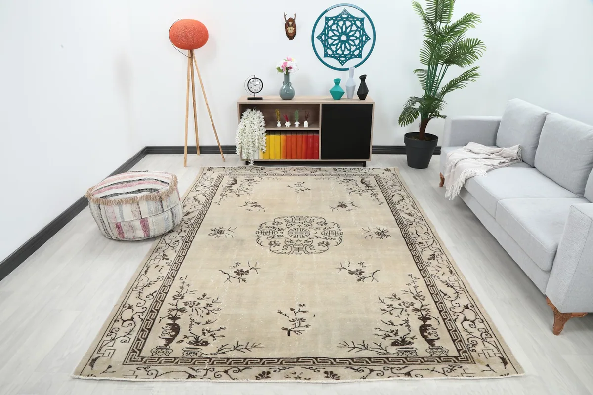 Vintage beige and brown rug displayed in a living room setting with a sofa.