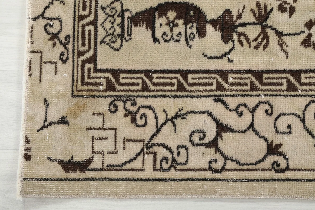 Corner detail showing the geometric border pattern and edge of the rug.