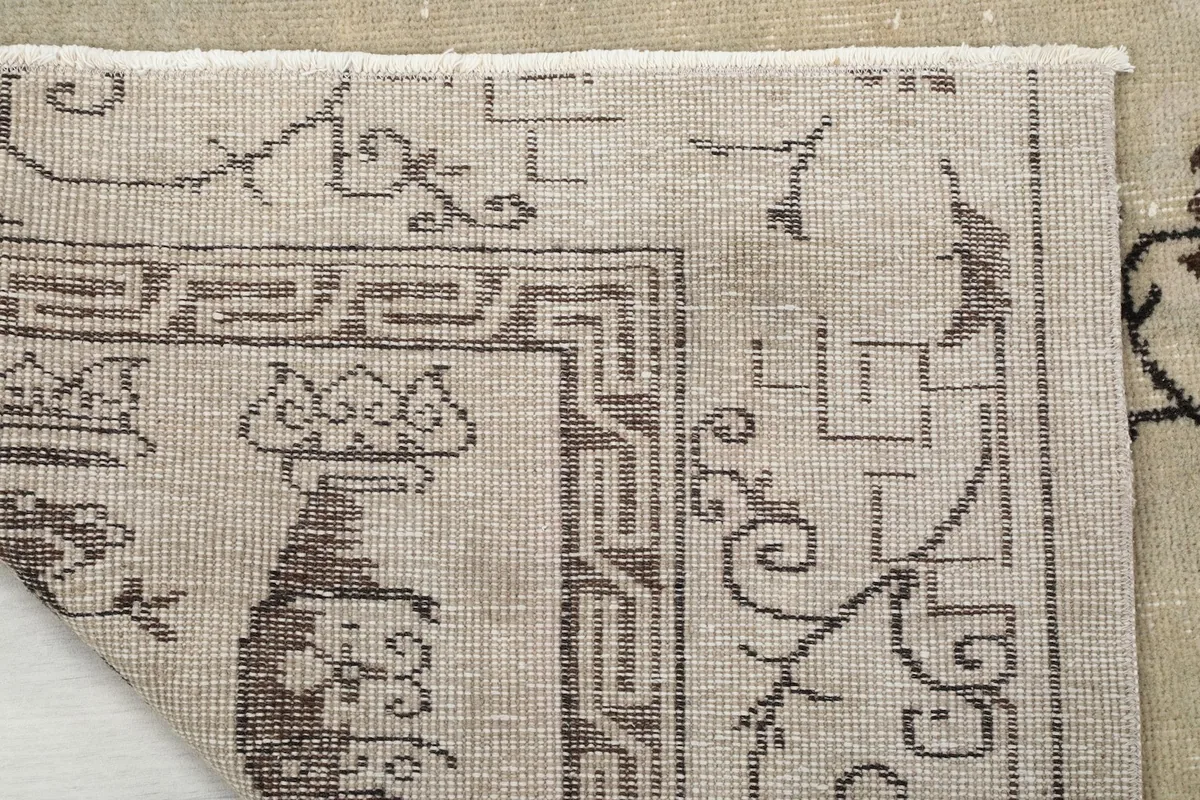 Close-up of the rug's reverse side, showing the hand-knotted cotton foundation.
