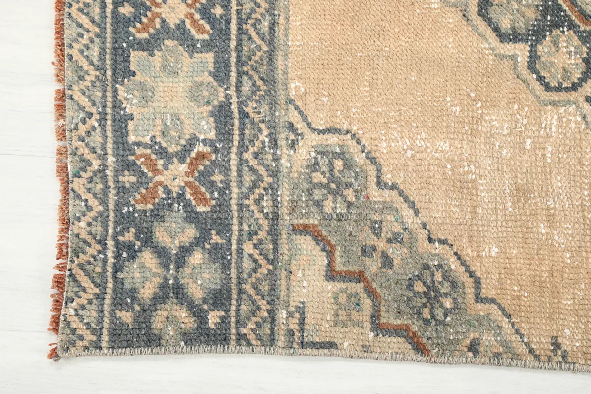 Detailed view of the runner's border with navy, rust, and gray motifs