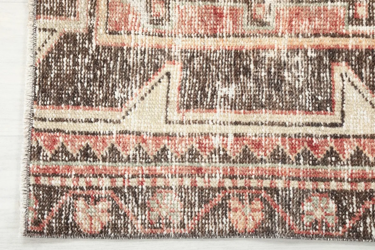 Close-up of the rug's border and fringe, revealing the hand-knotted construction.