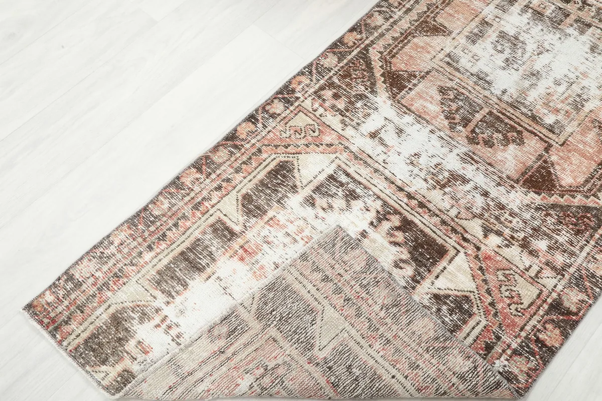 View of the rug folded back, showcasing the cotton foundation and reverse side of the knots.