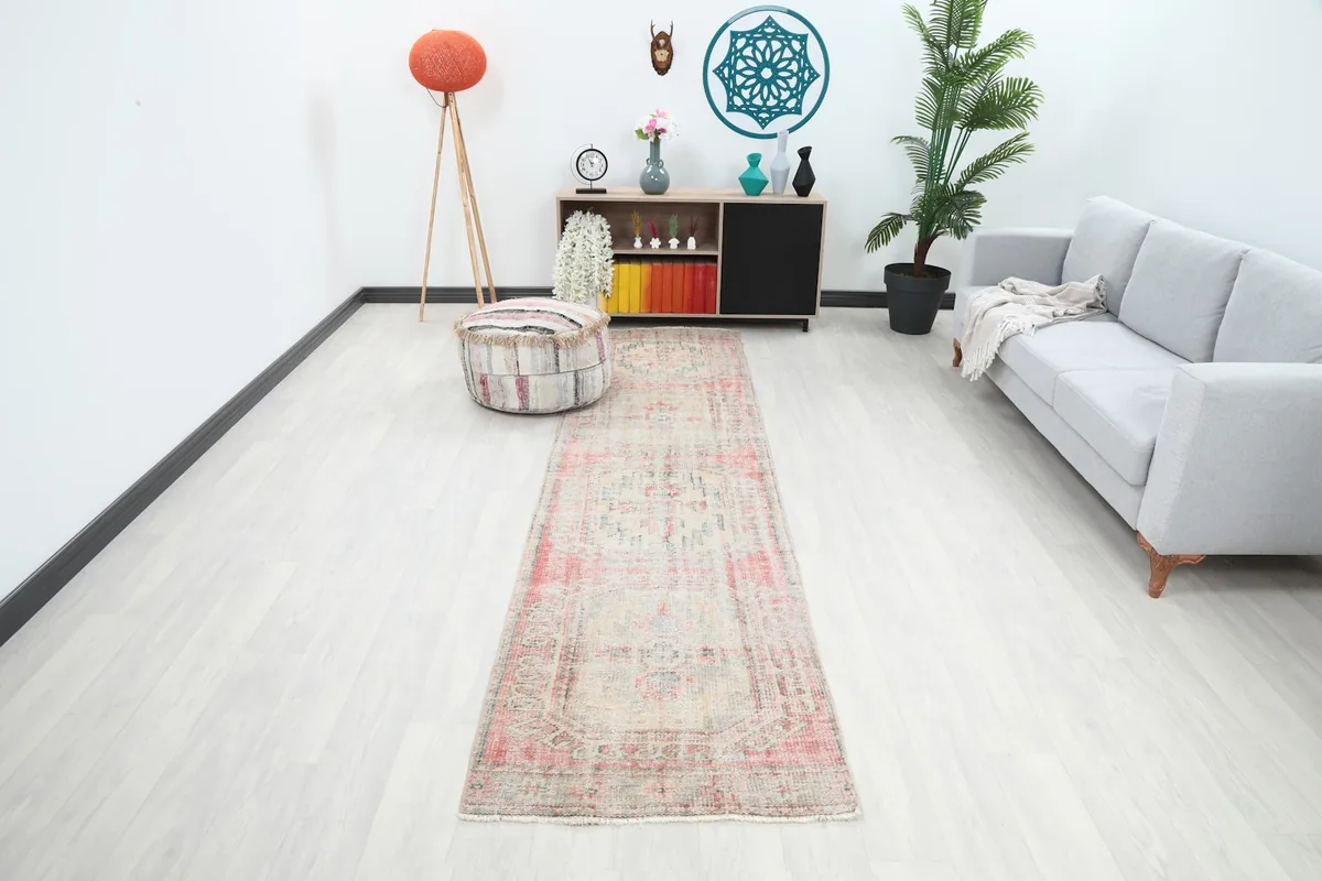Runner rug displayed in a modern living space with a gray sofa and wooden cabinet, showing its full length.