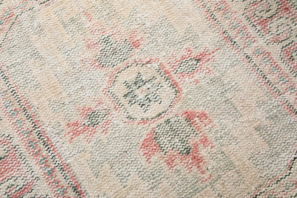 Extreme close-up of the rug's low wool pile, showing the intricate knotting and subtle color blend.