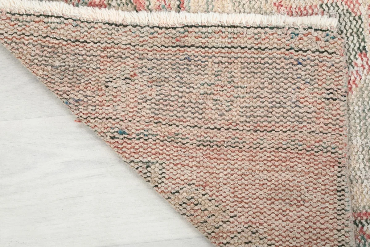 Detailed view of the rug's underside, revealing the tightly woven cotton foundation and knotting.