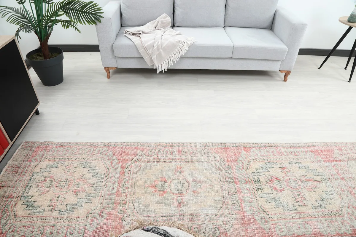 Overhead view of the runner rug in the room, showing its central medallions and faded colors.