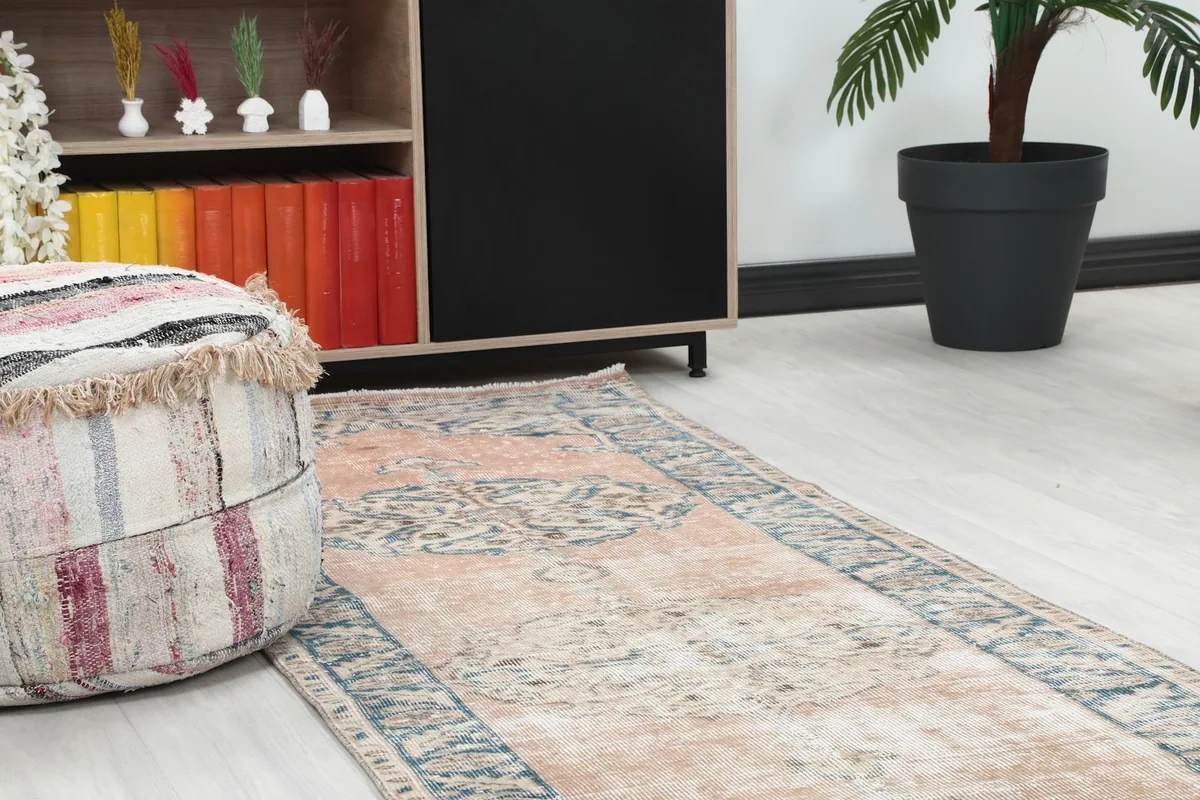 Close-up of the runner rug's end in a room setting, next to a decorative pouf