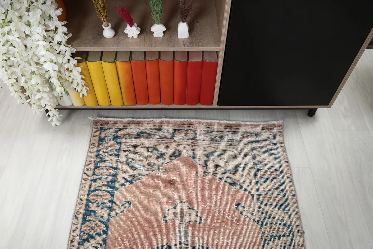 Top-down view of one end of the runner rug in a room, showing the initial medallion