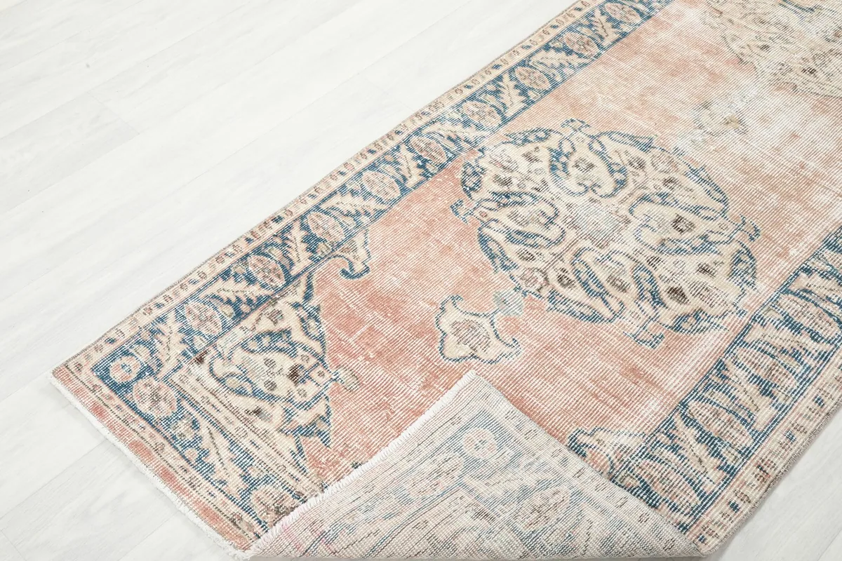 View of the runner rug with a corner folded back, revealing the reverse side of the weave