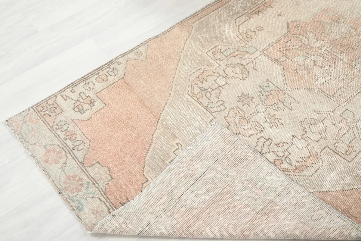 Folded corner of the rug revealing the wool pile and cotton foundation