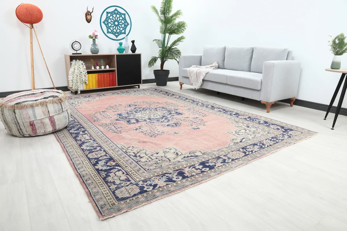 Rose Navy Medallion Anatolian Rug in a room with a gray sofa and decorative elements.