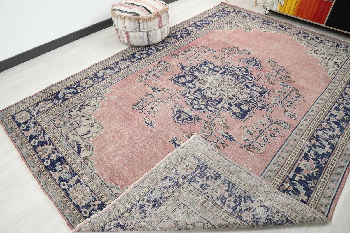 Rose Navy Medallion Anatolian Rug with a corner folded back, revealing the underside and pile.