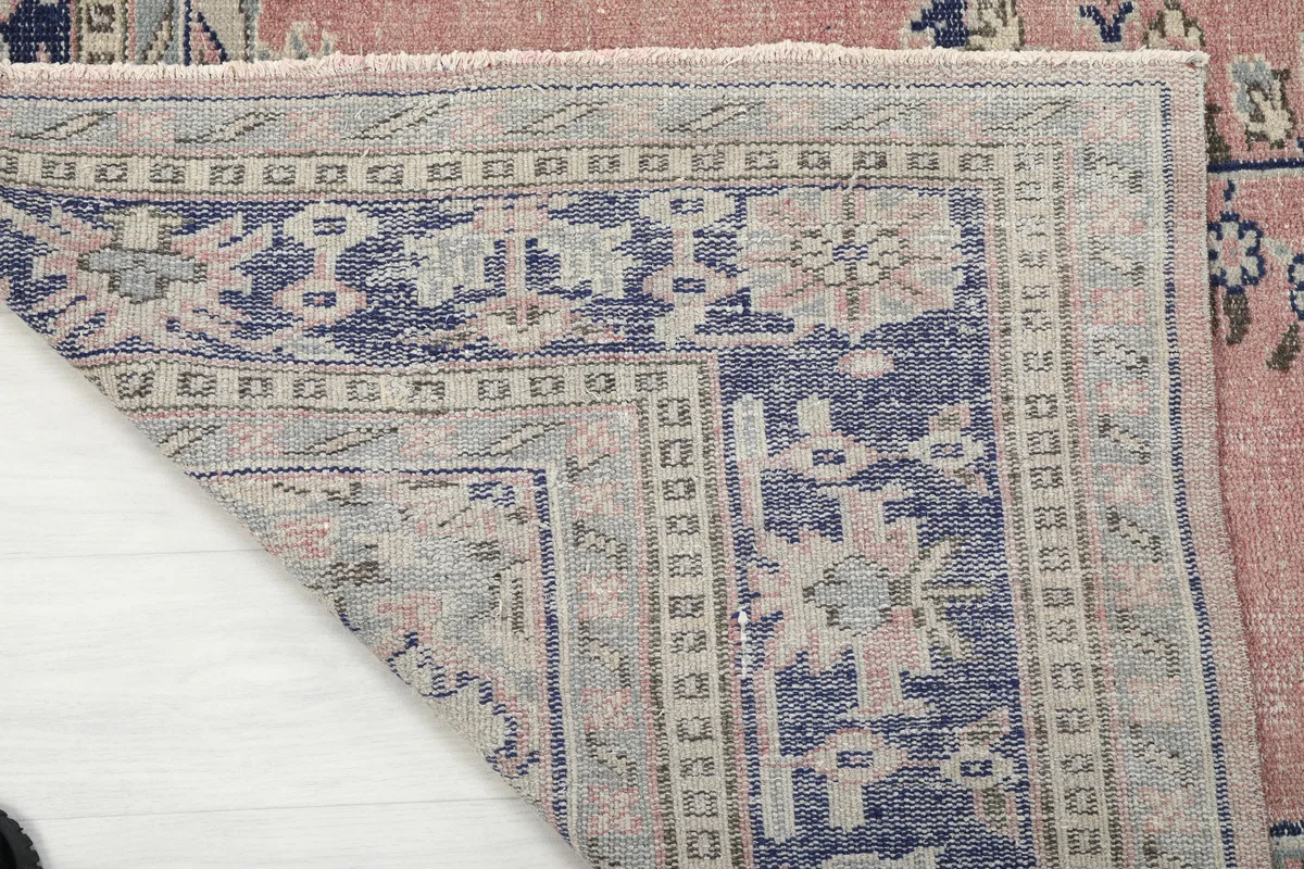 Close-up of the Rose Navy Medallion Anatolian Rug's folded corner, showing the back of the rug.