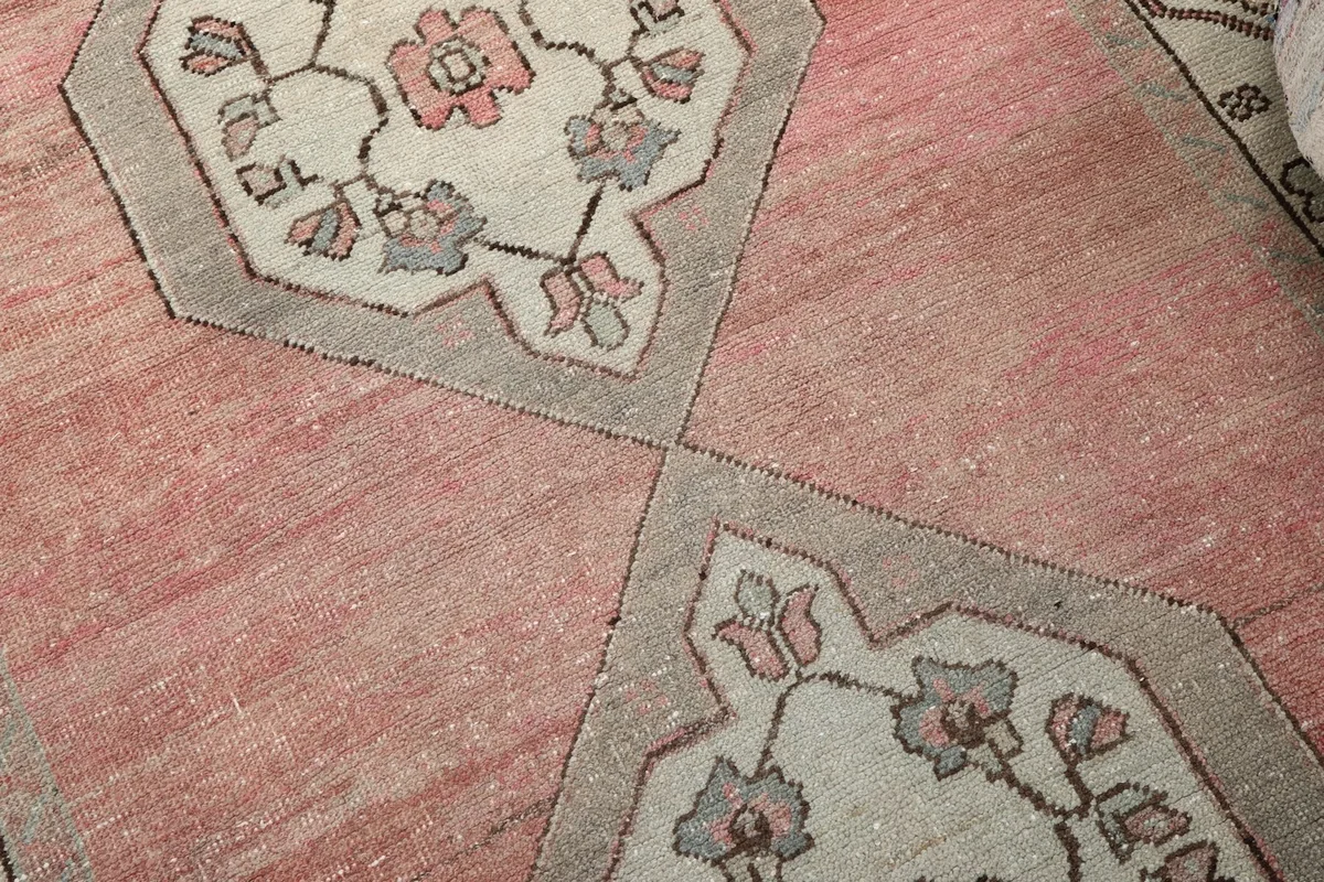 Close-up of the central geometric medallions with floral designs and the faded rose field.