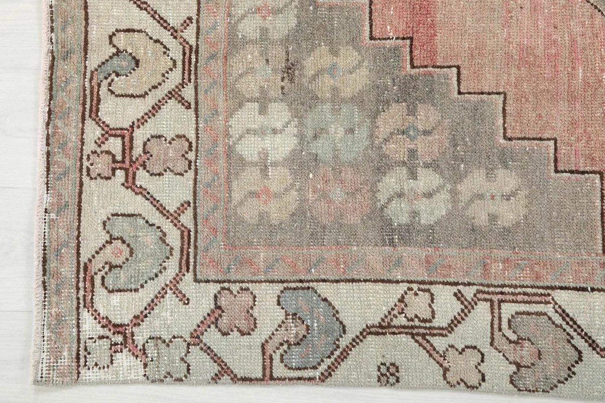 Detailed view of the rug's corner, showing the intricate border pattern and the transition to the field.