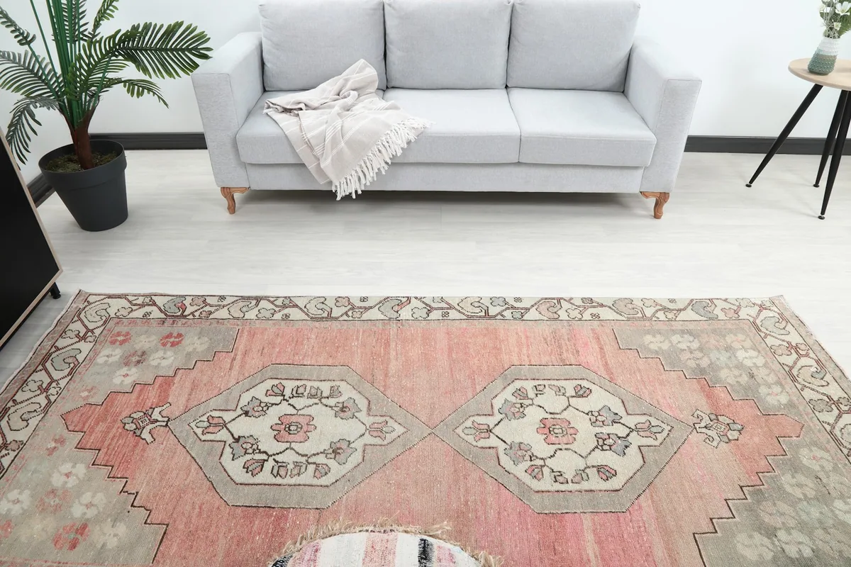 Overhead shot of the rug in a room, highlighting the central medallions and the surrounding decor.