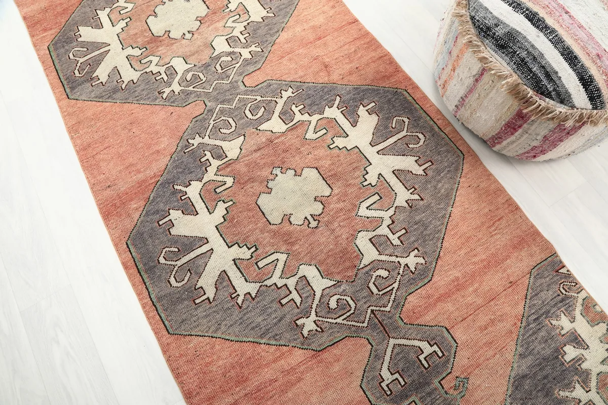 Diagonal view of the runner rug, emphasizing the repeating geometric medallions in rust and gray