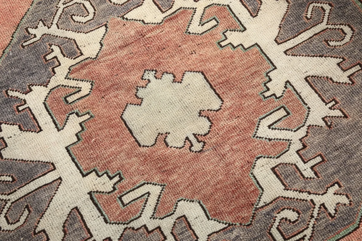 Close-up detail of a central geometric medallion, showing the wool knotting and color variations