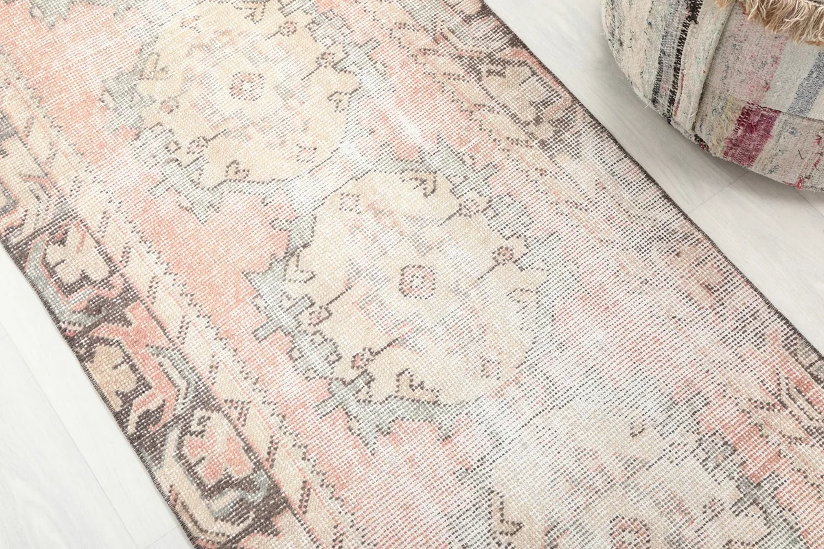 Detailed view of the rose and beige field with geometric motifs