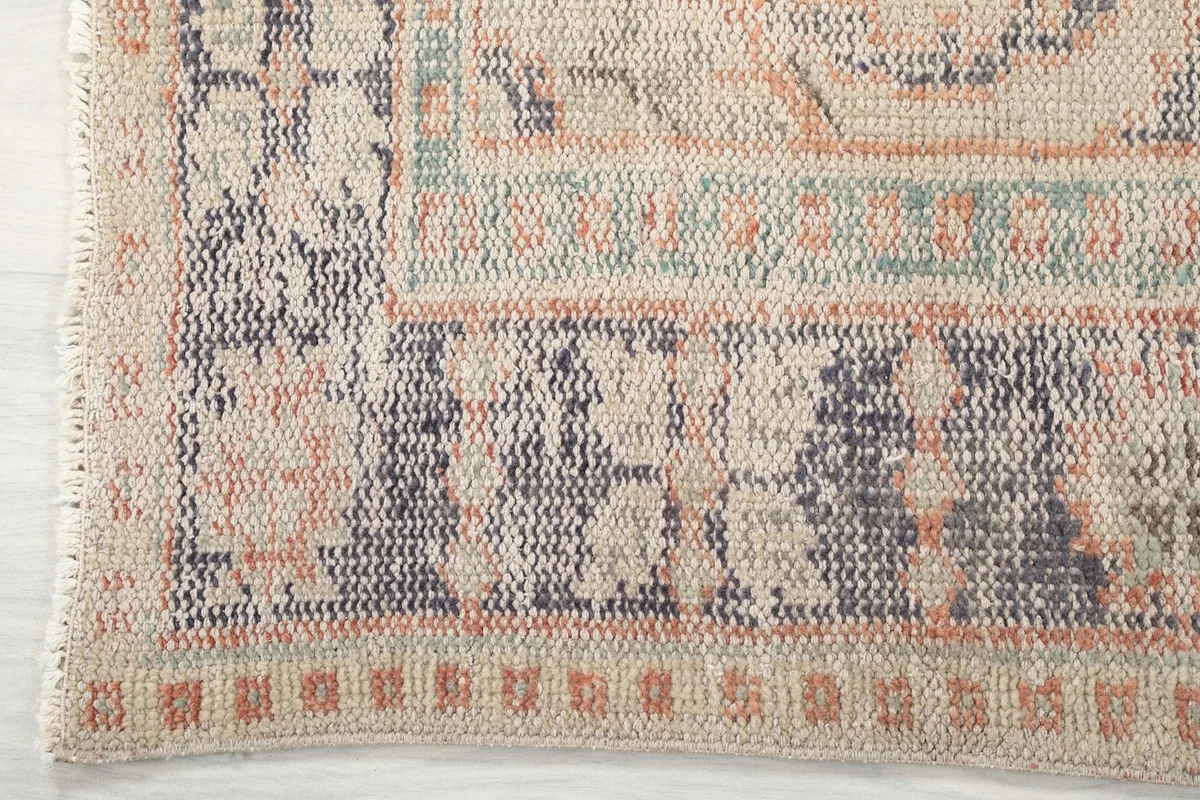 Detailed view of the rug's border design and corner, showing hand-knotted texture